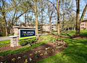 Thumbnail 30 of 40 - Community entrance monument sign with stone pillar at The Brook At Columbia Apartments, Columbia, 21044