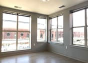 Thumbnail 4 of 10 - A room with large windows and wooden floors.