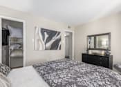 Thumbnail 25 of 56 - A bedroom with a large bed and a dresser with a mirror at Madison at Eden Brook, 21046