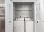 Thumbnail 31 of 56 - A white laundry room with a washer and dryer at Madison at Eden Brook, 21046
