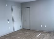 Thumbnail 5 of 10 - A room with grey walls and a grey floor with a white line in the middle.