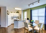 Thumbnail 17 of 34 - an open kitchen and dining room with a table and chairs at MetroPlace at Town Center, Maryland, 20746