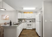 Thumbnail 3 of 34 - a kitchen with white appliances and granite counter tops and white cabinets at MetroPlace at Town Center, Camp Springs