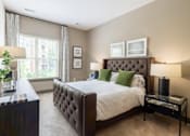 Thumbnail 11 of 84 - A bedroom with a large bed, a mirror, and a plant at Mira Upper Rock, Maryland, 20850