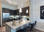 Thumbnail 6 of 84 - A modern kitchen with a granite countertop and stainless steel appliances at Mira Upper Rock, Maryland, 20850