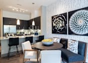 Thumbnail 5 of 84 - A modern kitchen with a dining table set for four at Mira Upper Rock, Maryland, 20850