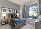 Thumbnail 5 of 24 - A bedroom with a bed, nightstand, and a window with curtains at Prairie Crossing, Texas