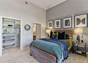 Thumbnail 6 of 24 - A bedroom with a bed, a nightstand, and a wall with picture frames at Prairie Crossing, Texas