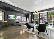 Thumbnail 15 of 24 - A modern living room with a large flat screen TV mounted on the wall at Prairie Crossing, Farmers Branch, TX 75244