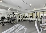 Thumbnail 17 of 24 - A gym with a variety of equipment including treadmills, weights, and exercise machines at Prairie Crossing, Texas 75244