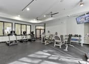 Thumbnail 18 of 24 - A spacious gym with a variety of equipment including treadmills, stationary bikes, and weight machines at Prairie Crossing, Farmers Branch, Texas