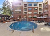 Thumbnail 20 of 24 - A pool in a courtyard surrounded by apartment buildings at Prairie Crossing, Farmers Branch, TX 75244