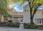 Thumbnail 45 of 54 - the front of a gray house with trees and a sidewalk at Villages at Morgan Metro, Landover, 20785