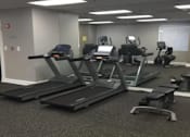 Thumbnail 10 of 10 - A gym with treadmills and elliptical machines.