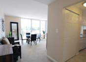 Thumbnail 2 of 10 - A living room with a dining table and chairs is shown.