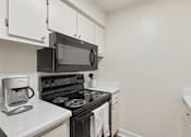 Thumbnail 13 of 33 - A black microwave oven is on the counter above a black stove at Riviera Park, Chandler Arizona