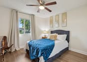 Thumbnail 17 of 33 - A bedroom with a bed, chair, and window at Riviera Park, Chandler Arizona