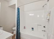 Thumbnail 16 of 33 - A white bathroom with a white tub and a white toilet at Riviera Park, Chandler Arizona
