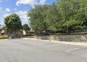 Thumbnail 43 of 54 - an empty parking lot with trees and a building in the background at Villages at Morgan Metro, Landover, MD