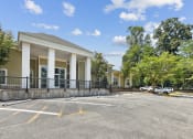 Thumbnail 38 of 54 - the entrance to a parking lot with a cream colored building with columns at Villages at Morgan Metro, Landover, MD