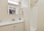Thumbnail 19 of 33 - A white bathroom with a sink and mirror at Riviera Park, Chandler Arizona
