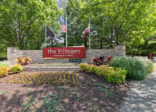 Thumbnail 37 of 54 - a sign for thevillages yards with flags and trees at Villages at Morgan Metro, Landover, MD, 20785