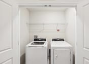 Thumbnail 18 of 30 - an empty laundry room with two washes and a dryer at Refinery Row, Baltimore, MD 21224