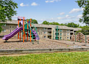 Thumbnail 23 of 40 - Colorful playground with climbing wall and mulch surface at The Brook At Columbia Apartments, Columbia, MD