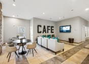 Thumbnail 30 of 54 - a lobby with a table and chairs and a coffee table and a television at Villages at Morgan Metro, Landover Maryland