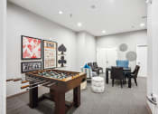 Thumbnail 31 of 54 - a game room with a foosball table and a dining room table and chairs at Villages at Morgan Metro, Landover, 20785