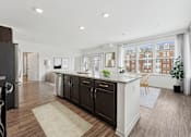 Thumbnail 2 of 49 - A kitchen with dark wood floors and white walls.
