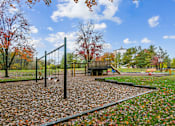 Thumbnail 41 of 45 - A playground with a swing set and a slide in the middle of a park  at Poplar Glen Apartments, Columbia, MD, 21044.