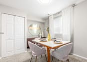 Thumbnail 9 of 40 - Dining room with round mirror and white table at The Brook At Columbia Apartments, Columbia