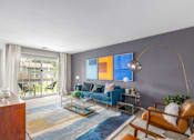 Thumbnail 6 of 40 - Living room with blue sofa and arched floor lamp at The Brook At Columbia Apartments, Maryland, 21044