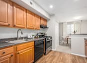 Thumbnail 5 of 40 - Galley kitchen with gas range and granite countertops at The Brook At Columbia Apartments, Columbia, MD