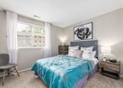 Thumbnail 13 of 40 - Bedroom with turquoise bedding and upholstered headboard at The Brook At Columbia Apartments, Columbia, 21044