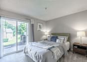Thumbnail 20 of 46 - A bedroom with a large bed and a sliding glass door.