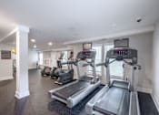 Thumbnail 30 of 46 - A gym with treadmills and elliptical machines.