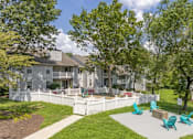 Thumbnail 44 of 46 - A white fence surrounds a green lawn with a white building in the background.