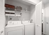 Thumbnail 25 of 46 - A white laundry room with a washer and dryer.