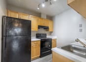 Thumbnail 9 of 46 - A kitchen with a black refrigerator, stove, and oven.