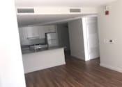 Thumbnail 2 of 8 - A kitchen with white cabinets and a wooden floor.