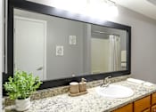 Thumbnail 18 of 65 - A bathroom with a sink, mirror, and a potted plant.