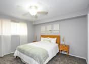 Thumbnail 19 of 81 - A bedroom with a bed, nightstand, and a ceiling fan.