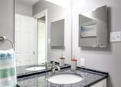 Thumbnail 25 of 81 - A bathroom with a black granite countertop and a white sink.