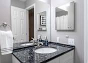 Thumbnail 17 of 65 - A bathroom with a black granite countertop and a white towel hanging on a towel ring.