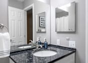 Thumbnail 27 of 81 - A bathroom with a black granite countertop and a white towel hanging on the towel rack.