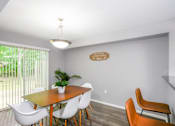 Thumbnail 79 of 81 - A dining room with a wooden table and white chairs.