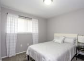 Thumbnail 80 of 81 - A bedroom with a white bed and a window with curtains.