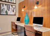 Thumbnail 33 of 54 - two computers sitting on a desk in a office with a vase at Villages at Morgan Metro, Landover, 20785